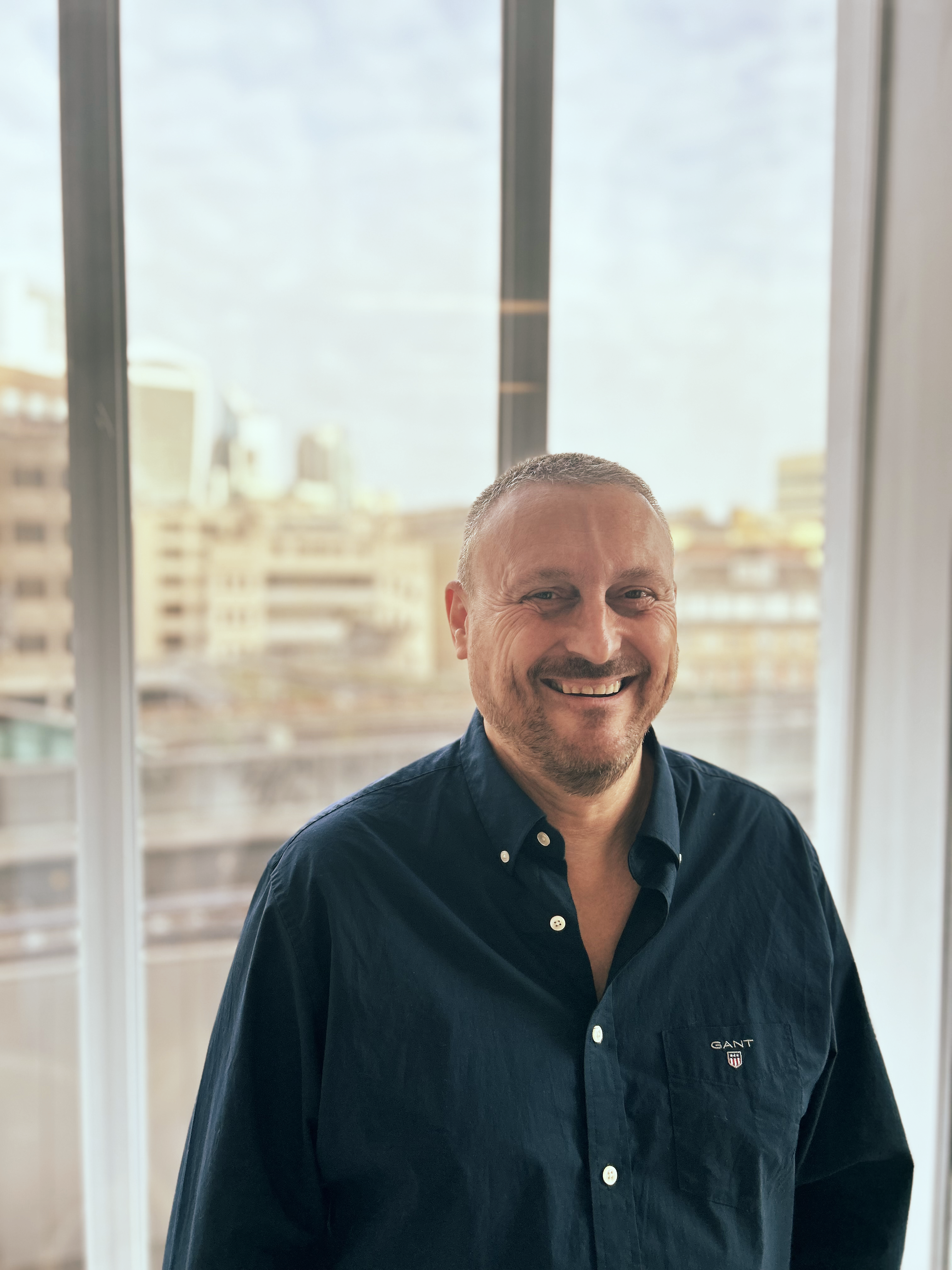 Kenny Hughes standing in Inicio's sunny London office